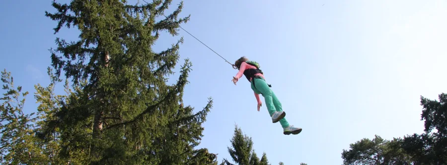 Teilnehmerin im Kletterwald neben Gut Schörghof während einer Teamentwicklung